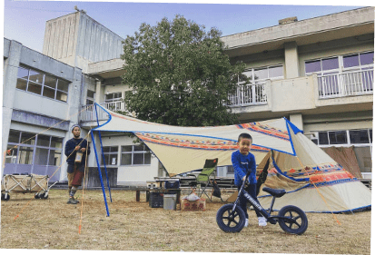 学校でオートキャンプを楽しむ家族の写真