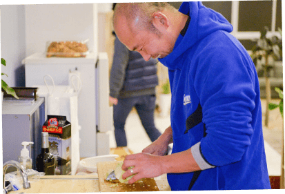 ミニキッチンで調理する男性の写真